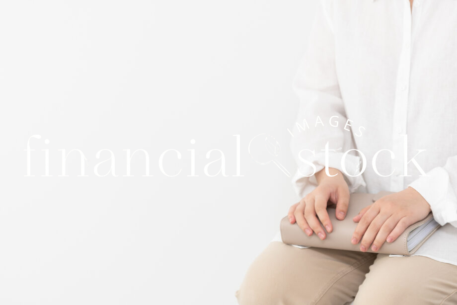 Financial Stock Images - Woman working from home holding a beige diary-copyspace