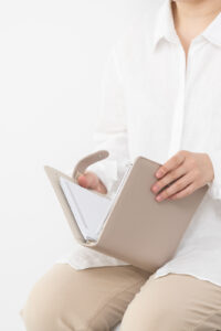 Financial Stock Images - Woman working from home holding a beige diary.